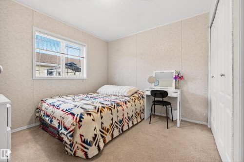 This room features a window with horizontal blinds, carpeted flooring, and a closet with bi-fold doors - 1727 Jubilee Loop, Sherwood Park, AB - Indoor Photo Showing Bedroom
