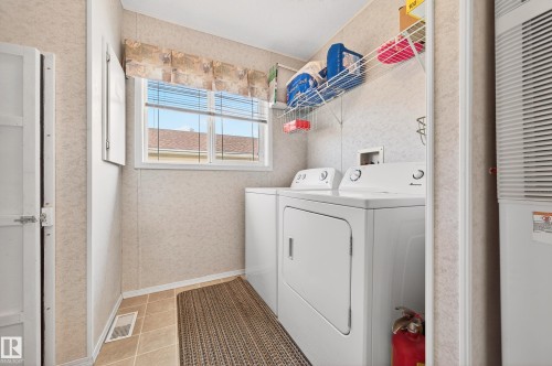 Utility room featuring a window with blinds, tile flooring, and a laundry appliance set - 1727 Jubilee Loop, Sherwood Park, AB - Indoor Photo Showing Laundry Room