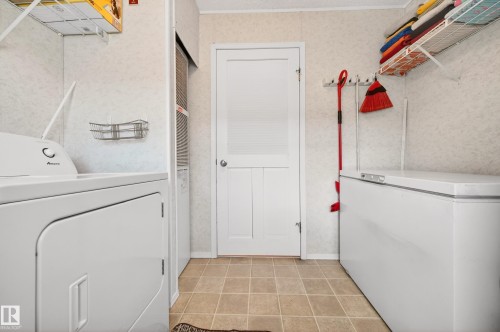 The laundry area features tile flooring and includes a washer and dryer - 1727 Jubilee Loop, Sherwood Park, AB - Indoor Photo Showing Laundry Room