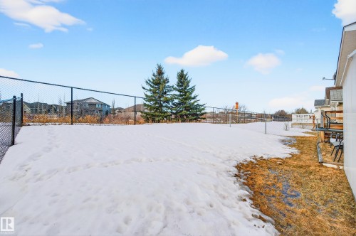 The property features an extensive outdoor space with a fenced perimeter and mature evergreen trees - 1727 Jubilee Loop, Sherwood Park, AB - Outdoor