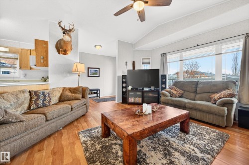 The living area features wood flooring, a ceiling fan, and large windows providing natural light - 1727 Jubilee Loop, Sherwood Park, AB - Indoor Photo Showing Living Room