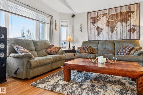 Living area featuring hardwood floors, a large window with blinds, and a textured area rug - 1727 Jubilee Loop, Sherwood Park, AB - Indoor Photo Showing Living Room