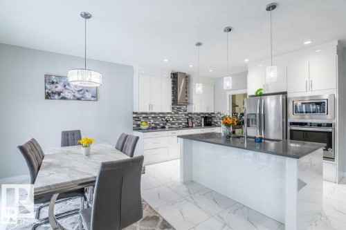 Well-appointed kitchen featuring a large island, stainless steel appliances, white cabinetry, and recessed lighting - 3608 46 Avenue, Beaumont, AB - Indoor