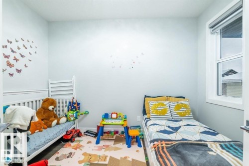 This room features light-colored walls and a window with a white frame - 3608 46 Avenue, Beaumont, AB - Indoor Photo Showing Bedroom