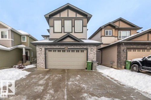 The property features a two-story exterior with siding and stone accents, a prominent front-facing garage, and a paved driveway - 3608 46 Avenue, Beaumont, AB - Outdoor With Facade