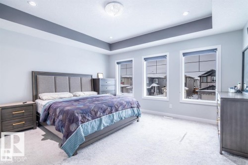 The room features a tray ceiling with recessed lighting and a chandelier - 3608 46 Avenue, Beaumont, AB - Indoor Photo Showing Bedroom