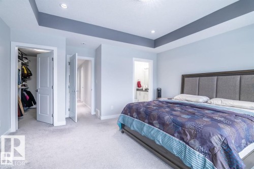 Bedroom featuring light grey carpeting, recessed lighting, and a tray ceiling with a contrasting grey accent - 3608 46 Avenue, Beaumont, AB - Indoor Photo Showing Bedroom