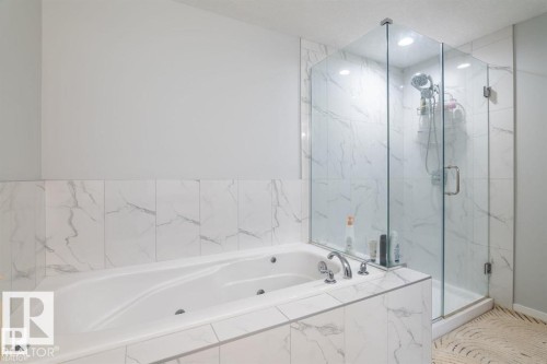 Bathroom featuring a bathtub and a glass-enclosed shower with tiled walls - 3608 46 Avenue, Beaumont, AB - Indoor Photo Showing Bathroom