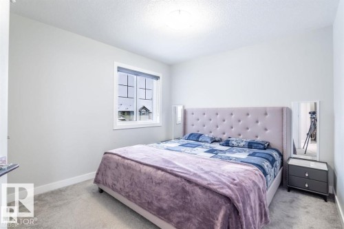 This room features light-colored walls and grey carpet flooring - 3608 46 Avenue, Beaumont, AB - Indoor Photo Showing Bedroom
