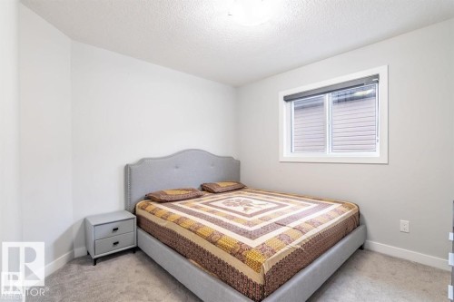 Bedroom featuring light gray walls, gray carpet, and a window with blinds - 3608 46 Avenue, Beaumont, AB - Indoor Photo Showing Bedroom