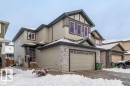 The property features a two-story exterior with light-colored siding, a stone facade, and dark trim details - 3608 46 Avenue, Beaumont, AB  - Outdoor With Facade 