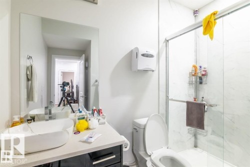 Bathroom featuring a vessel sink on a countertop, a toilet, and a stand-up shower with a glass enclosure - 3608 46 Avenue, Beaumont, AB - Indoor Photo Showing Bathroom