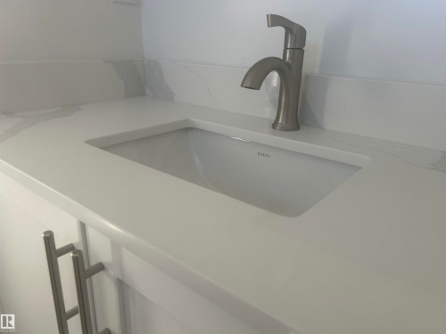 Contemporary vanity with an integrated rectangular sink, a light-colored countertop, and a brushed metal faucet - 14911 77 Street Nw, Edmonton, AB - Indoor Photo Showing Other Room