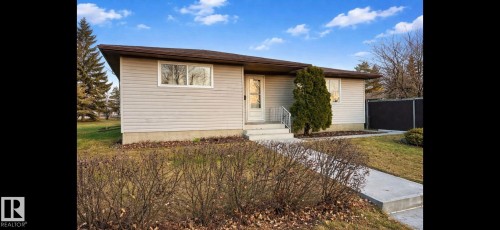 The property features a concrete walkway leading to the front entry, which includes a white door with glass inserts and a metal handrail - 14911 77 Street Nw, Edmonton, AB - Outdoor