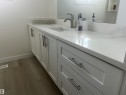 Bathroom vanity with white cabinetry, a white countertop, and a built-in sink with a chrome faucet - 14911 77 Street Nw, Edmonton, AB  - Indoor Photo Showing Other Room 
