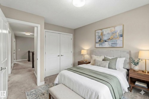 This bedroom features plush carpeting, white double bi-fold closet doors, and neutral wall tones - 5014 Dewolf Road, Edmonton, AB 