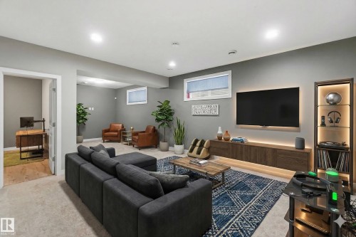 Spacious living area featuring recessed lighting, light gray walls, and a large window - 5014 Dewolf Road, Edmonton, AB 