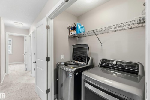 Dedicated laundry area featuring a wire rack shelf and space for laundry appliances - 5014 Dewolf Road, Edmonton, AB 