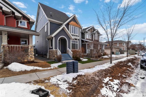 The property features a stone and siding exterior with a prominent arched entry and front-facing porch - 5014 Dewolf Road, Edmonton, AB 