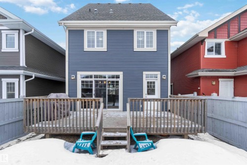 The property features a private deck with wooden railings and steps, accessible via sliding glass doors - 5014 Dewolf Road, Edmonton, AB 