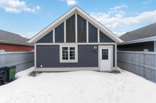The property features a detached structure with blue siding, a white trim window, and a white door with a window - 5014 Dewolf Road, Edmonton, AB 