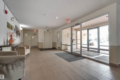 The property features a well-lit entrance area with large windows, providing natural light, and a tiled floor - 304 17151 94A Avenue, Edmonton, AB - Indoor Photo Showing Other Room