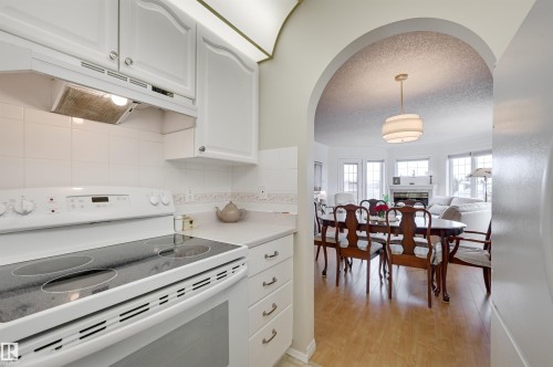 Kitchen featuring white cabinetry and appliances, including a range with a smooth cooktop - 304 17151 94A Avenue, Edmonton, AB - Indoor Photo Showing Kitchen