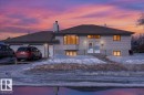 The property features a two-car garage, multiple windows providing natural light, and a sloped front yard - 13304 130 Avenue, Edmonton, AB  - Outdoor 