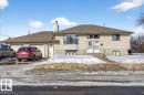 The property features a two-car garage with a paved driveway, and a light-colored siding exterior - 13304 130 Avenue, Edmonton, AB  - Outdoor 