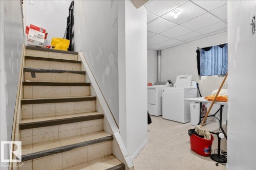 Laundry area with white washer and dryer units, a drop ceiling, and light-colored flooring - 13304 130 Avenue, Edmonton, AB - Indoor Photo Showing Laundry Room