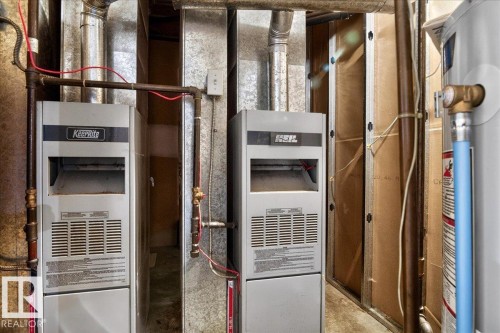 The property features two furnaces and a water heater, with exposed ductwork and copper piping - 13304 130 Avenue, Edmonton, AB - Indoor Photo Showing Basement