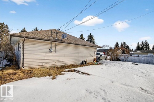 The property features a durable shingle roof, a light-colored siding exterior, and a spacious yard with a wooden fence - 13304 130 Avenue, Edmonton, AB - Outdoor With Exterior