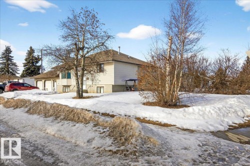 The property features a white exterior with a brown roof and a double garage - 13304 130 Avenue, Edmonton, AB - Outdoor