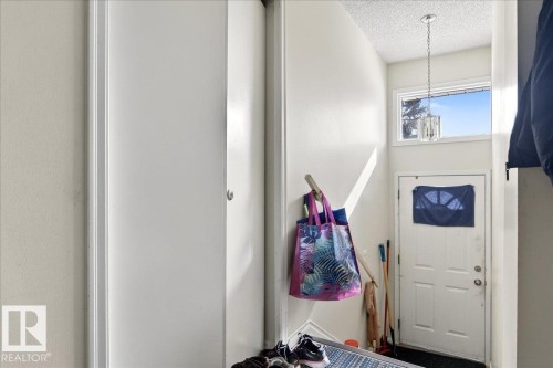 Entryway with high ceilings, a window above the entry door, and a hanging light fixture - 13304 130 Avenue, Edmonton, AB - Indoor Photo Showing Other Room