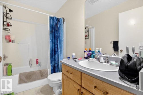 Bathroom featuring a vanity with a sink and storage cabinets, a toilet, and a shower and bathtub combination - 13304 130 Avenue, Edmonton, AB - Indoor Photo Showing Bathroom