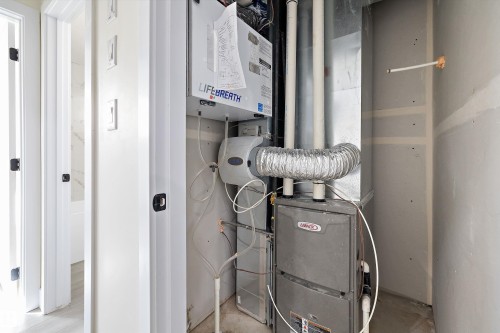 Utility area featuring a furnace and a "Lifebreath" air exchanger - 8321 81Ave, Edmonton, AB - Indoor Photo Showing Basement