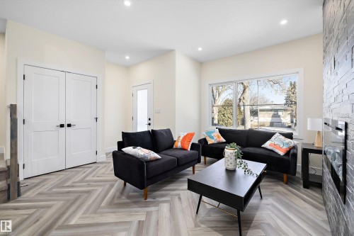 Living area featuring light-toned walls, recessed lighting, and herringbone pattern flooring - 8321 81Ave, Edmonton, AB - Indoor Photo Showing Living Room