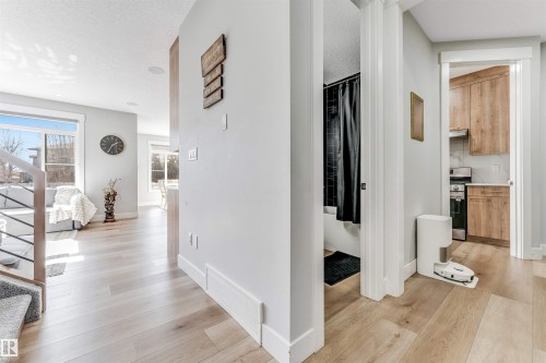 This property features light-toned hardwood flooring throughout the main living areas, with a carpeted staircase - 1531 151 Avenue, Edmonton, AB - Indoor