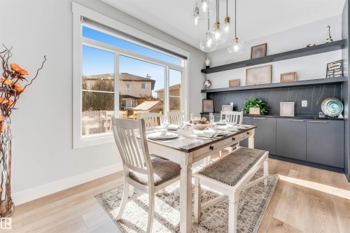 Dining area featuring light hardwood flooring, a large window, and built-in shelving with cabinetry - 1531 151 Avenue, Edmonton, AB - Indoor Photo Showing Dining Room