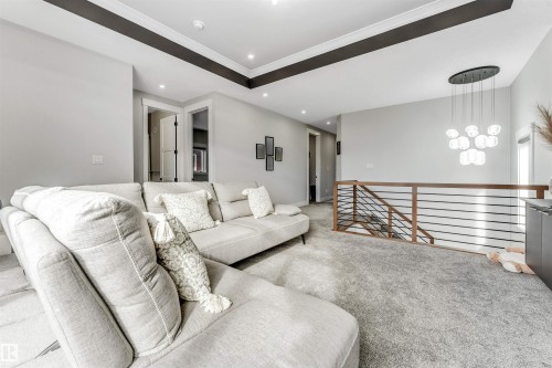 Spacious landing area with recessed lighting, a modern hanging light fixture, and a contemporary horizontal railing system - 1531 151 Avenue, Edmonton, AB - Indoor