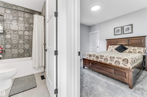 A well-appointed bedroom featuring light gray walls, plush gray carpet, and a wooden bed frame - 1531 151 Avenue, Edmonton, AB - Indoor Photo Showing Bedroom