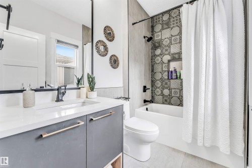 The bathroom features a vanity with a white countertop and a rectangular sink, complemented by a large mirror - 1531 151 Avenue, Edmonton, AB - Indoor Photo Showing Bathroom