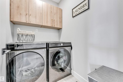 This laundry area features light wood cabinetry, white walls, and a light-colored baseboard - 1531 151 Avenue, Edmonton, AB - Indoor Photo Showing Laundry Room