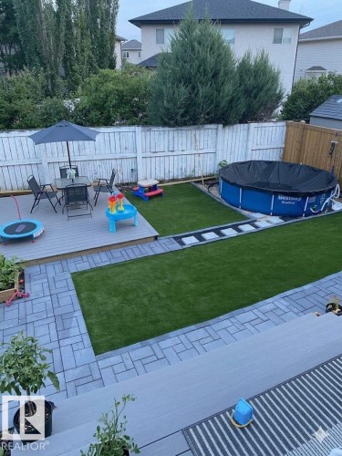 This property features a spacious backyard with a deck, a paved patio area, and a lawn - 1531 151 Avenue, Edmonton, AB - Outdoor With Backyard