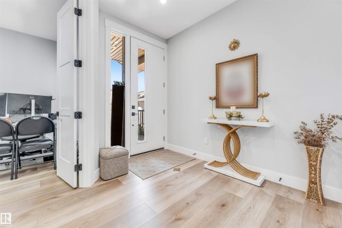 The entryway features light-toned wood flooring, a white front door with glass panels, and light grey walls - 1531 151 Avenue, Edmonton, AB - Indoor