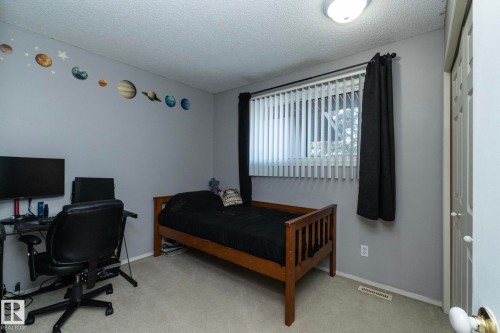 Bedroom featuring light gray walls, carpeted flooring, a window with vertical blinds and dark curtains, and a white paneled door - 6 Glaewyn Estates, St. Albert, AB - Indoor Photo Showing Bedroom