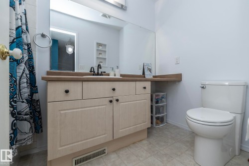 Bathroom featuring a vanity with a light-colored countertop and cabinetry, a large mirror, and a white toilet - 6 Glaewyn Estates, St. Albert, AB - Indoor Photo Showing Bathroom
