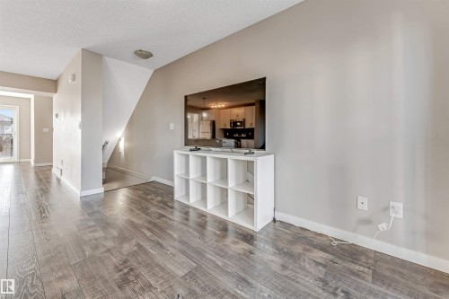 The interior of the property features plank flooring, light-colored walls, and a staircase - 1624 33A Street, Edmonton, AB - Indoor Photo Showing Other Room