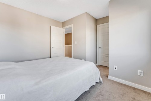 This room features neutral-toned walls, a white door with horizontal paneling, and carpeting - 1624 33A Street, Edmonton, AB - Indoor Photo Showing Bedroom