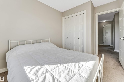 Bedroom featuring neutral-toned walls, carpeted flooring, and a closet with bifold doors - 1624 33A Street, Edmonton, AB - Indoor Photo Showing Bedroom
